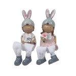 Rózsaszín ruhás lógólábú figura